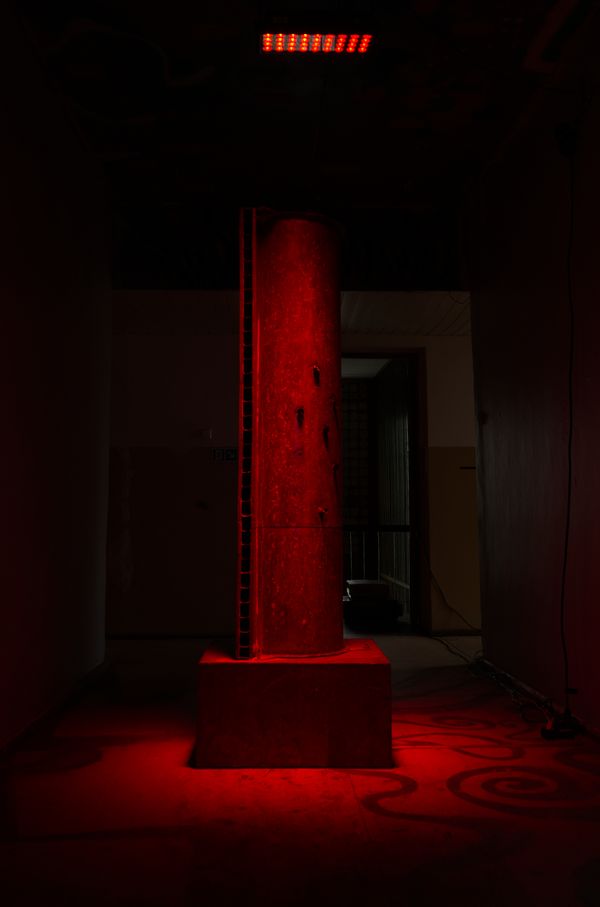 The Pipe Synthesizer standing in red light in a dark room