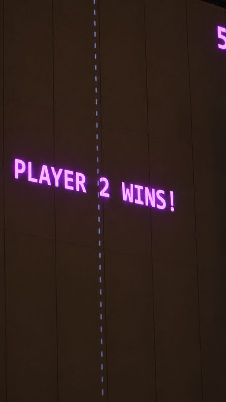 Close-up of the words Player 2 wins projected in violet on the wall