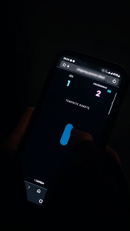 A phone in the dark showing the game: the score, one to two, and a paddle to drag